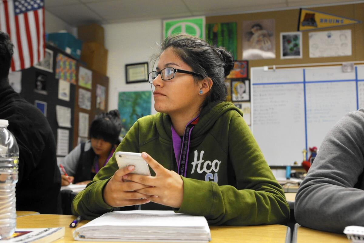 Kimberly Ceballos, a student in English teacher Priscilla Farinas' class at Social Justice Humanitas Academy in San Fernando, uses her cellphone as part of a lesson on “The Great Gatsby.”