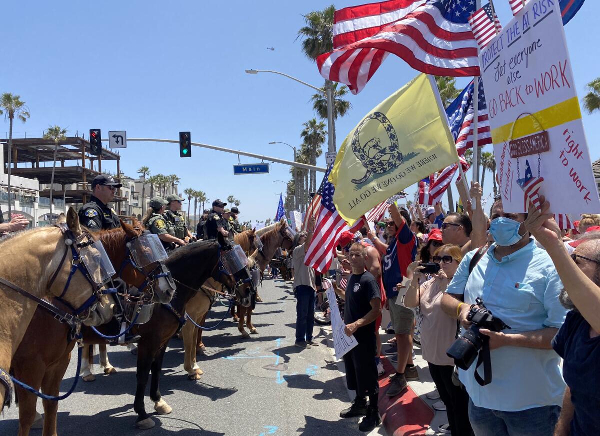 Demonstrators gather on Main Street and Pacific Coast Highway in Huntington Beach on May 1.