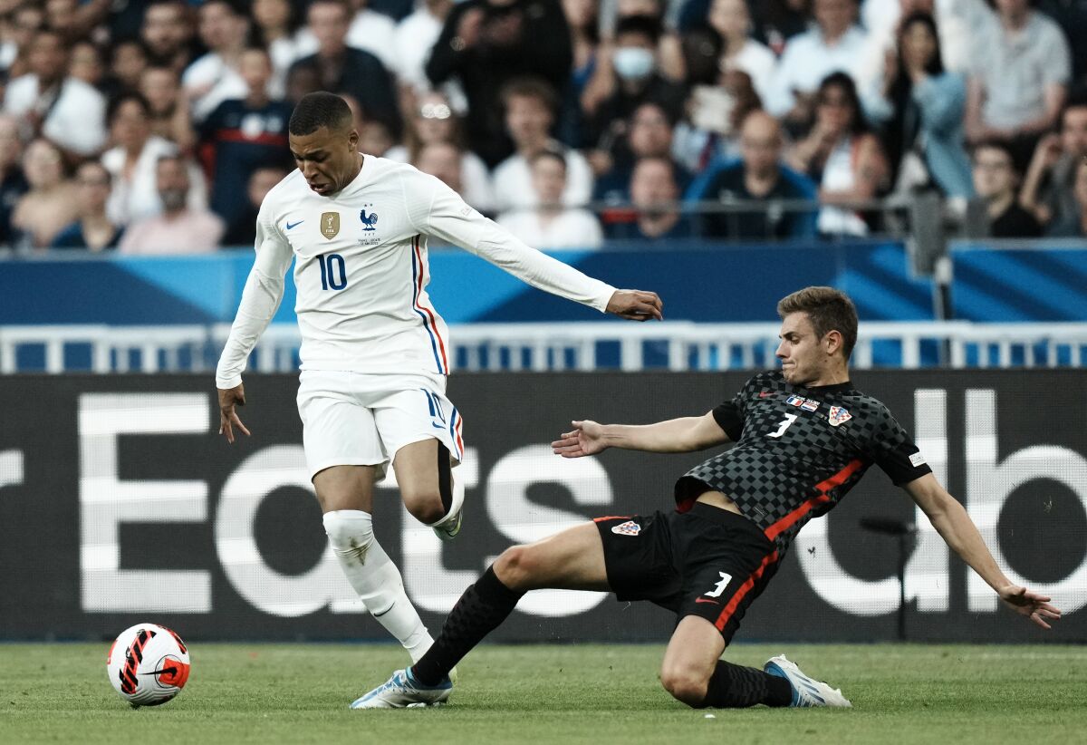 France's Kylian Mbappe, left, duels for the ball with Croatia's Josip Stanisic during the UEFA Nations League soccer match between France and Croatia at the Stade de France in Saint Denis near Paris, Monday, June 13, 2022. (AP Photo/Thibault Camus)