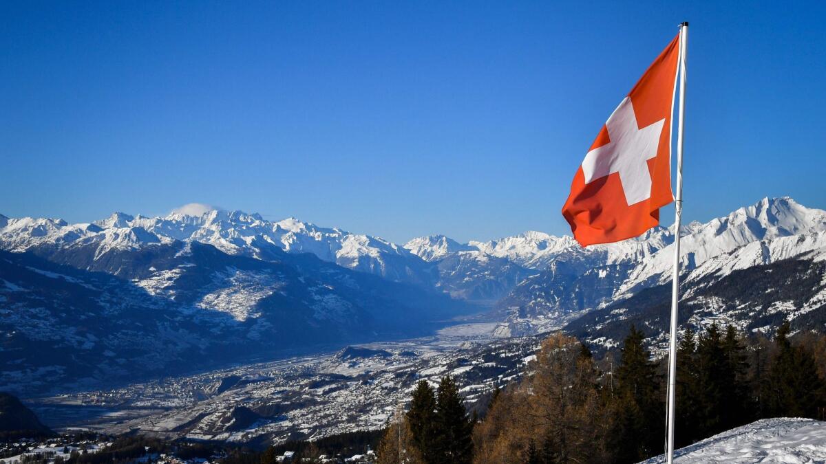 A Swiss flag floats above the Rhone's valley in the Swiss canton of Valais on March 4.