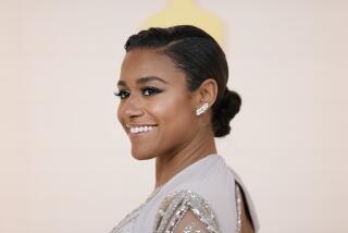 Ariana DeBose smiles in a sparkly dress against a cream background