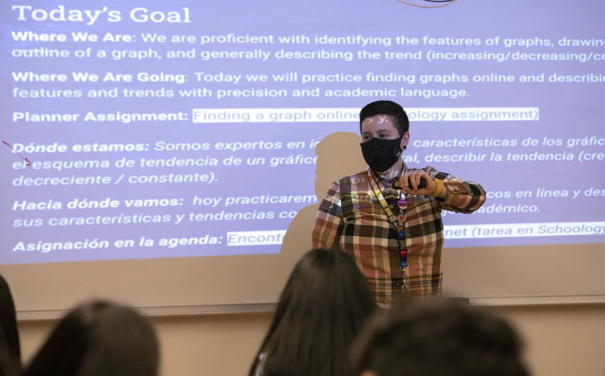 A teacher in front of a projection screen