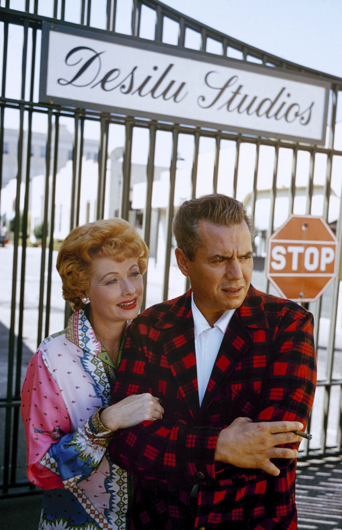 A woman and a man standing outside a Hollywood studio building with a sign that says "Desilu Studios."