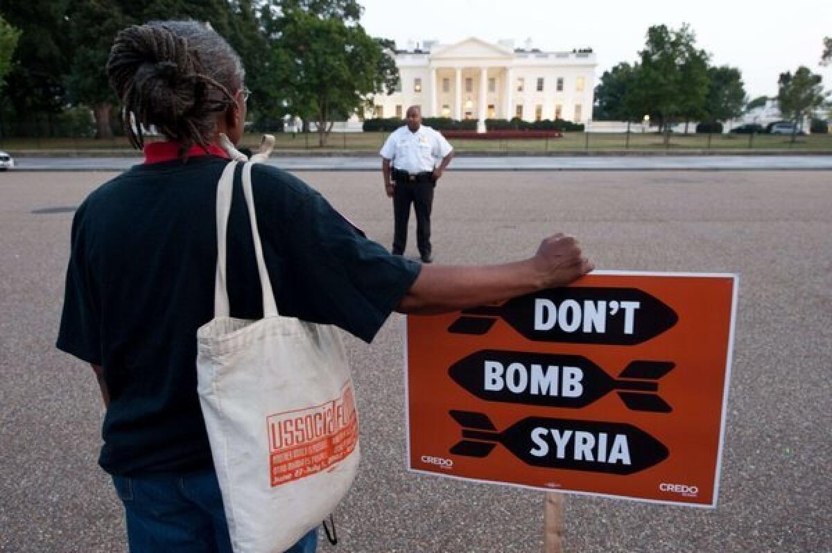 An anti-war demonstrator is seen outside the White House before President Obama addressed the nation on Syria Tuesday.