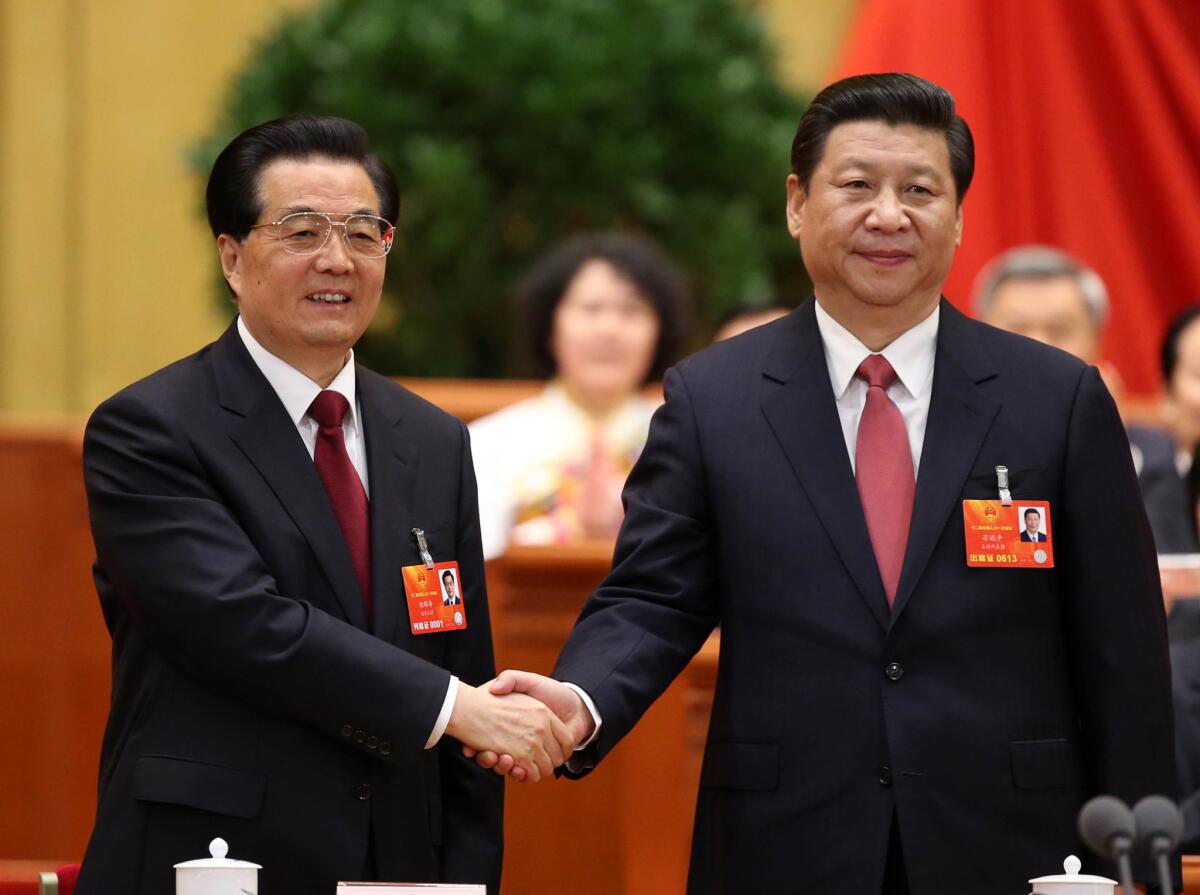 Outgoing Chinese President Hu Jintao, left, congratulates his successor, Xi Jinping, after Xi was elected to the presidency at a plenary meeting of the National People's Congress in Beijing.