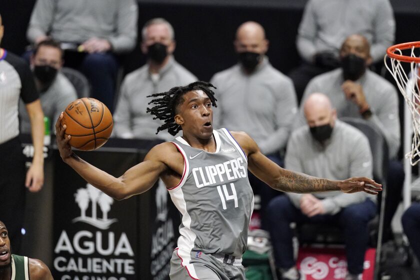 Los Angeles Clippers guard Terance Mann, right, goes up for a shot as Milwaukee Bucks forward Khris Middleton watches during the first half of an NBA basketball game Monday, March 29, 2021, in Los Angeles. (AP Photo/Mark J. Terrill)