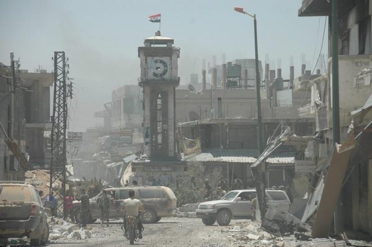 Syrian soldiers patrol damaged areas in the city of Qusair after claiming to have seized control of the city. Some opposition activists say rebel forces remain in part of the strategic city.