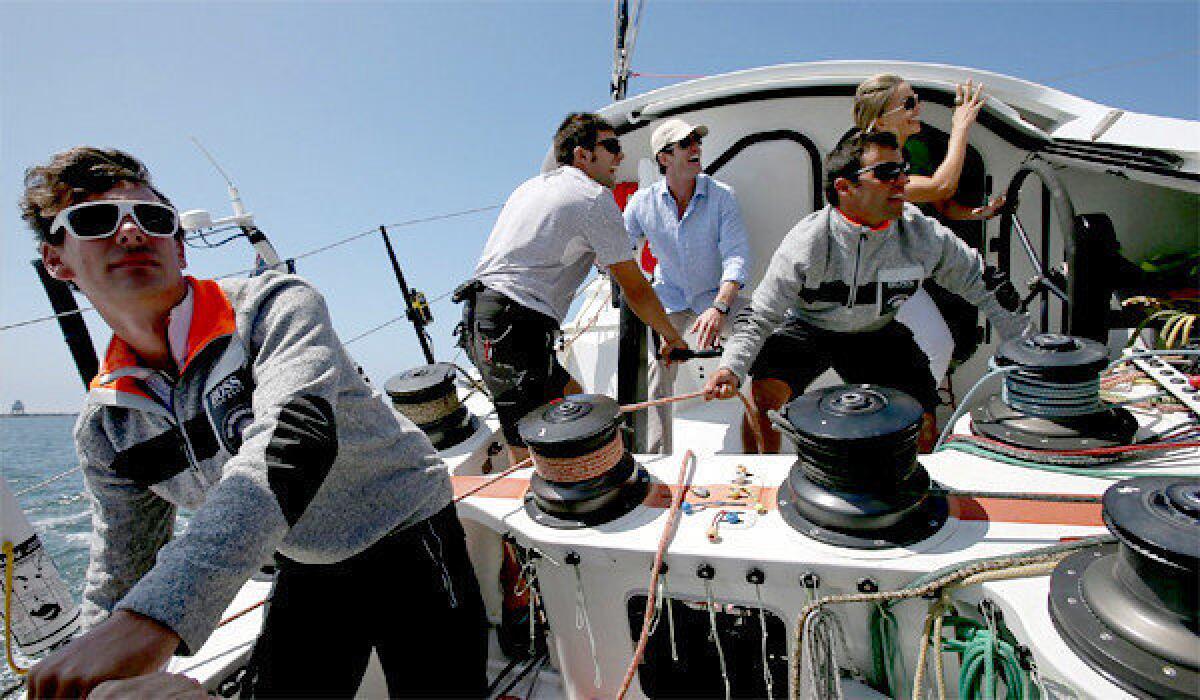 The support crew of the 60-foot Alex Thomson/Hugo Boss race boat sail the sleek craft in the waters off Long Beach on Tuesday.