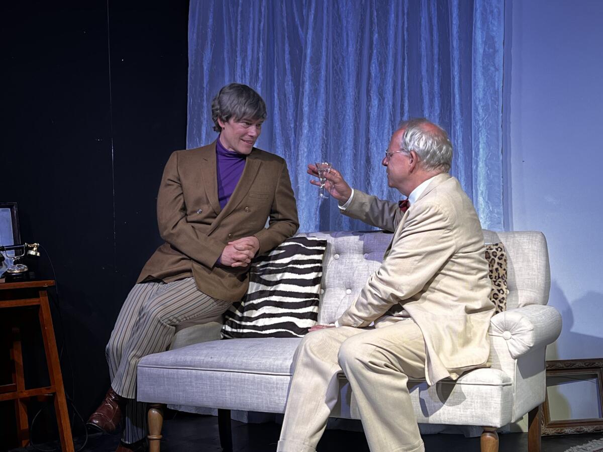 Two men talk on a white loveseat  in  the play "Fam and Yam."