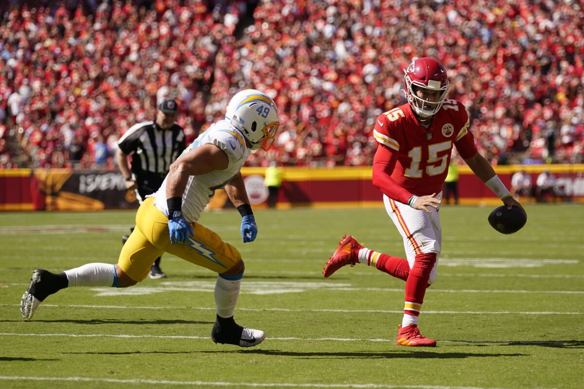  Chiefs quarterback Patrick Mahomes (15) is chased by Chargers' Drue Tranquill (49).