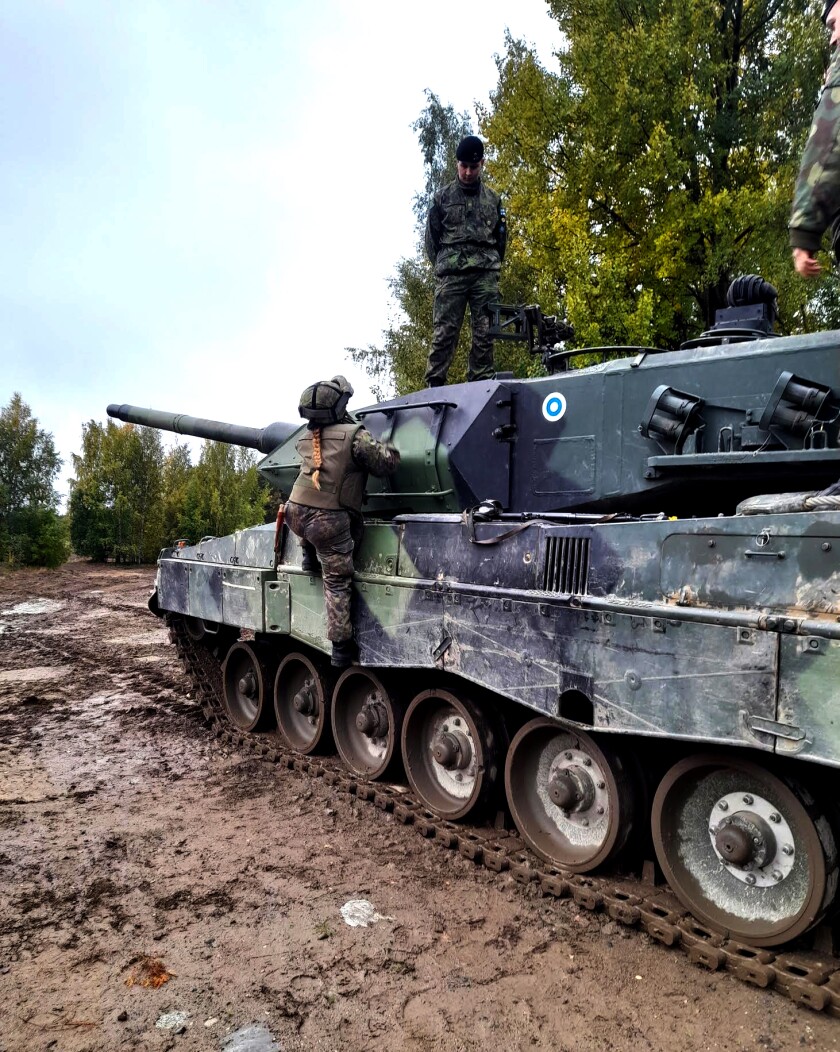 A female soldier on a tank.