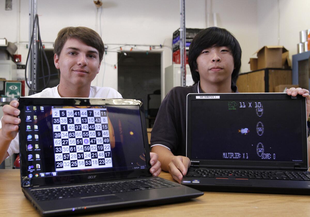 Crescenta Valley High School senior Trevor Fonda, left, who recently won 3rd place, and sophomore Justin Park, who recently won 2nd place, in the 28th Congressional District Science Technology, Engineering and Math (STEM) Competition, show off their apps at the La Crescenta school on Wednesday, May 28, 2014. Fonda invented an app that solved a game called A Knight's Journey and Park made an app called Mission Multiplication which is a math game.