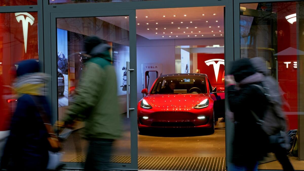 People walk past a Tesla dealership in Berlin.