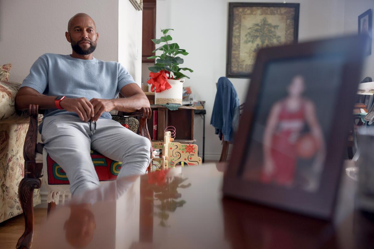 Brooklyn McLinn, rests on a chair with a picture of him from college seen right at his home.