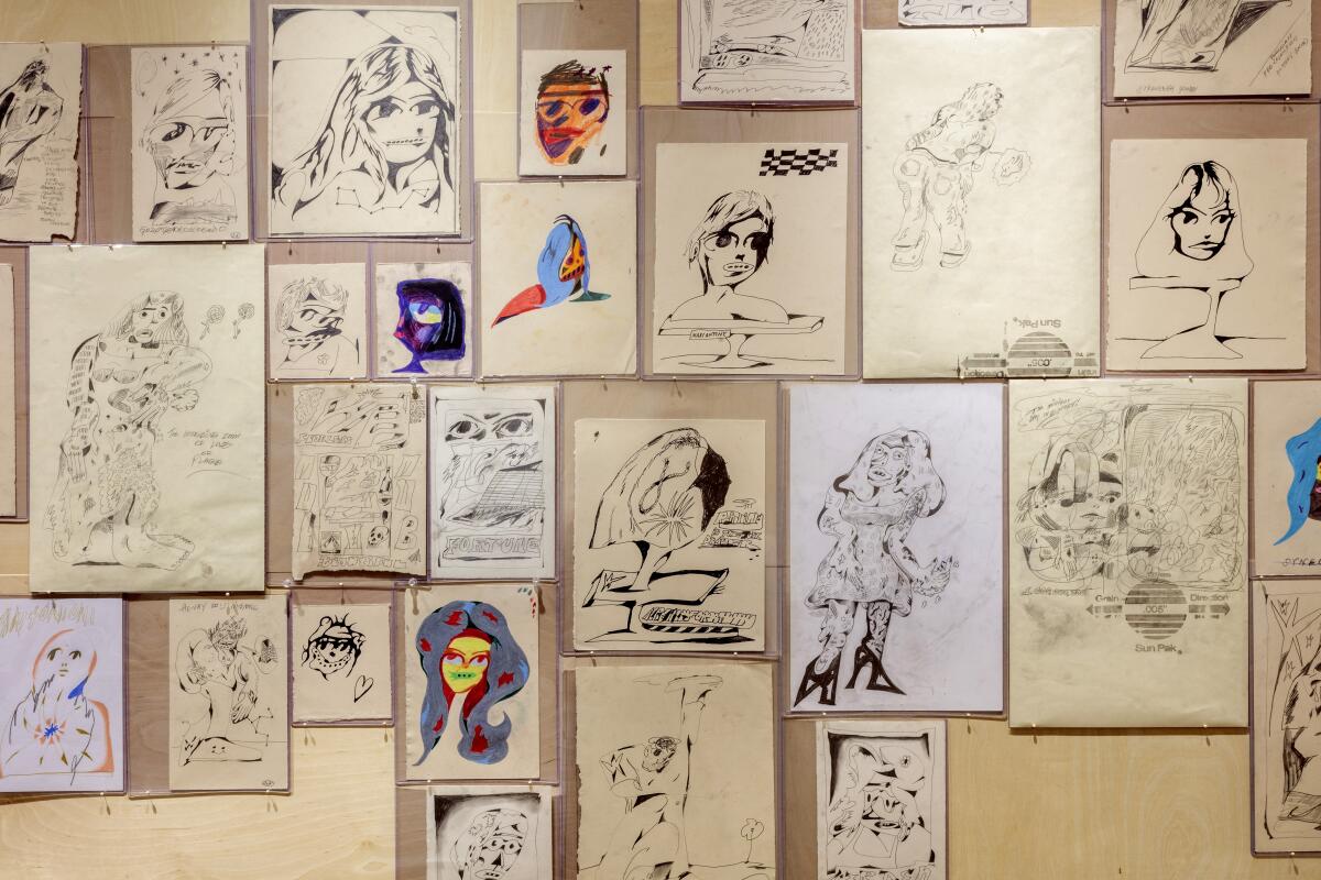 Small drawings collaged on the wall.