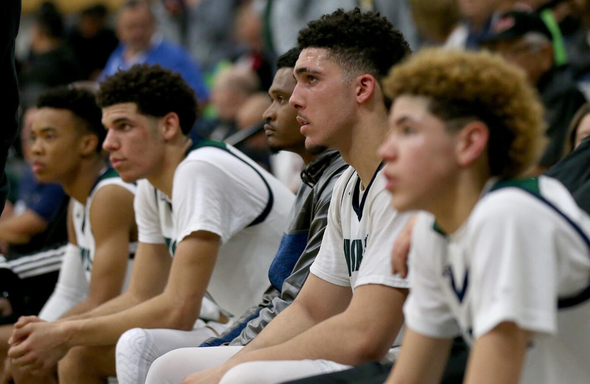 LiAngelo Ball, center, is flanked by brothers Lonzo, second from left, and LaMelo, right. during a playoff game Friday against Immanuel.