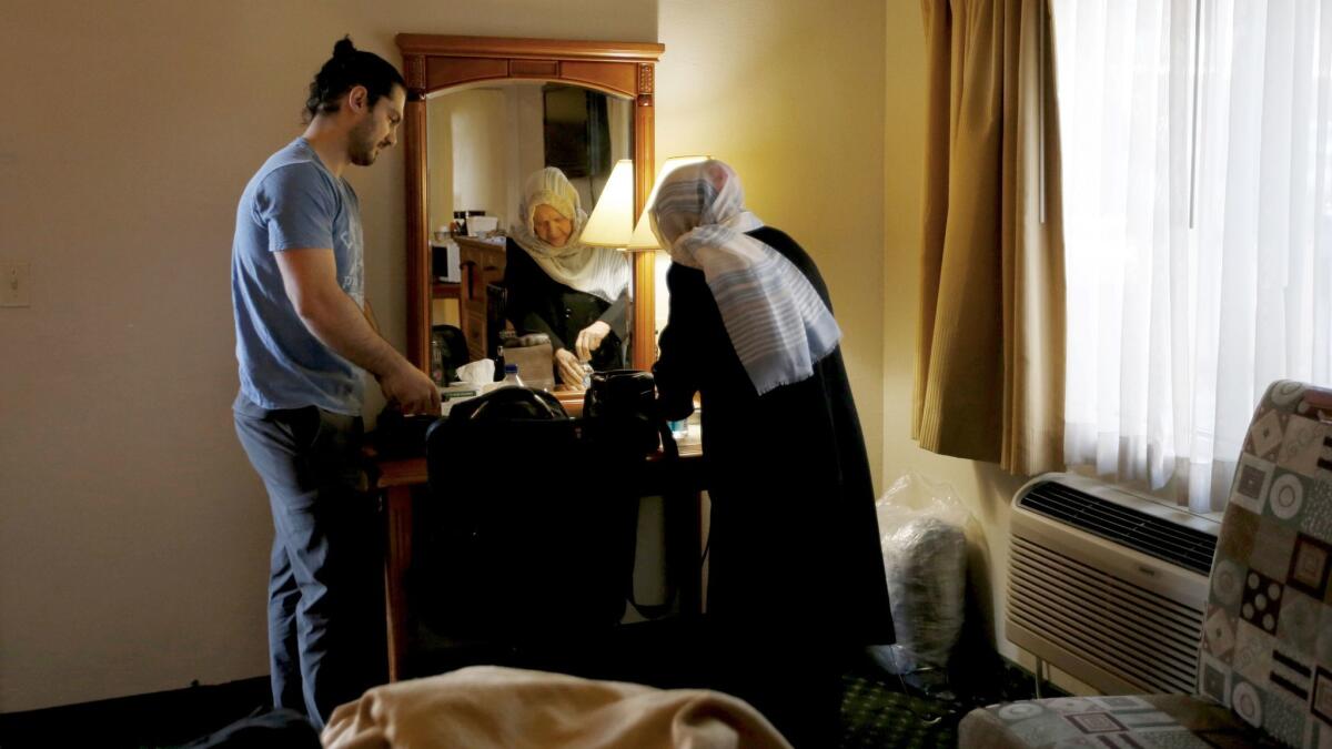 Siavosh Naji-Talakar, left, helps his grandmother Marzieh Moosavizadeh, 75, pack at their hotel near LAX in El Segundo.