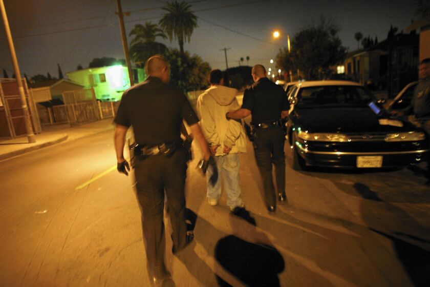 LAPD officers arrest a suspected gang member in 2009, during the period when violent crimes were underreported by 7%.