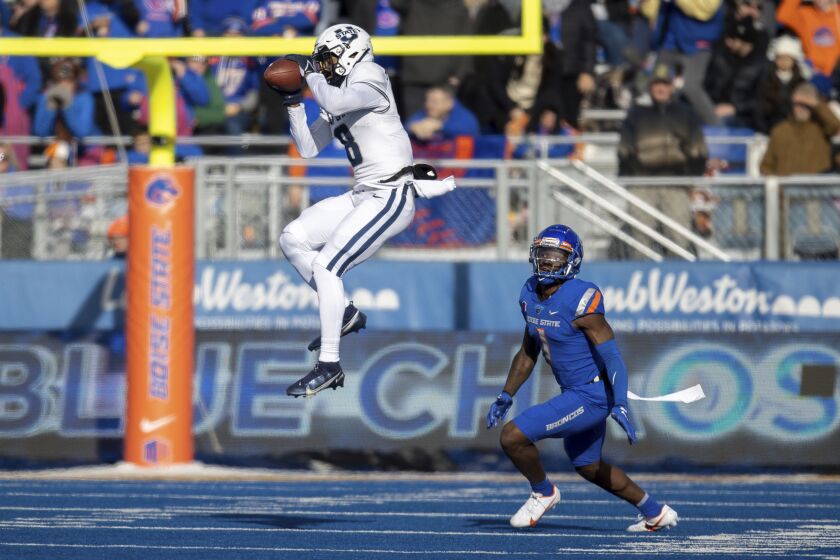 Utah State wide receiver Brian Cobbs (8) catches the ball in front of Boise State cornerback Caleb Biggers (1) in the first half of an NCAA college football game, Friday, Nov. 25, 2022, in Boise, Idaho. (AP Photo/Steve Conner)