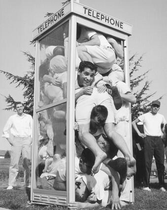 Twenty-one young men in T-shirts and shorts pile into on top of one another in a telephone booth at St. Marys College of California in Moraga in 1959.