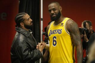 Drake and LeBron James #6 of the Los Angeles Lakers shake hands and talk after an NBA game