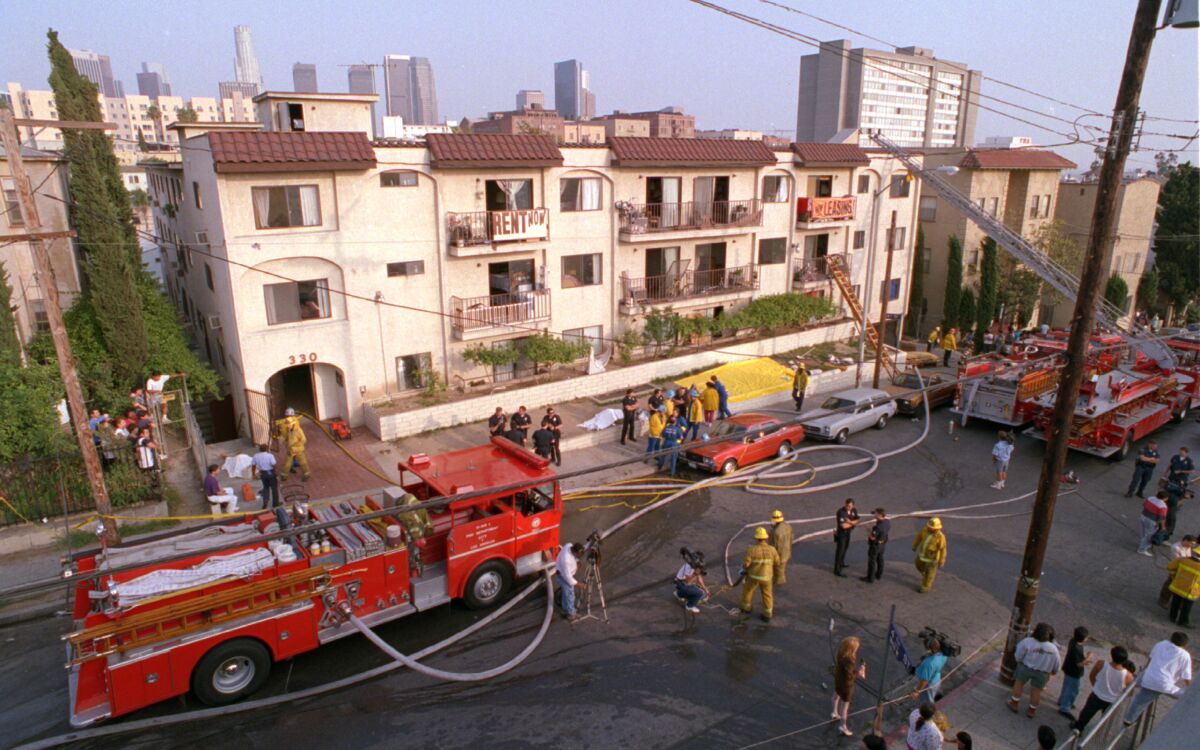 Firetrucks are parked in front of an apartment building.