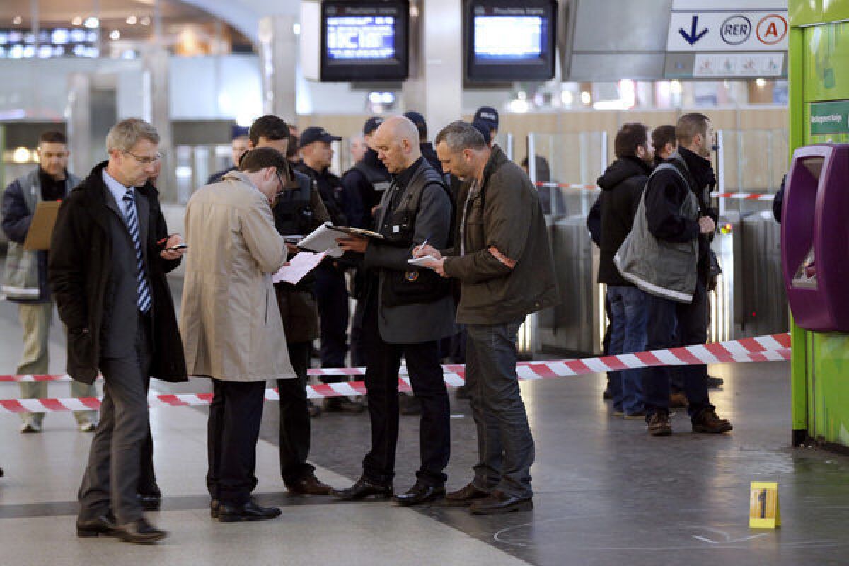 Police investigators and forensic experts work at the site where a man armed with a knife or box cutter attacked a French soldier patrolling a subway station on Saturday, stabbing him in the neck.