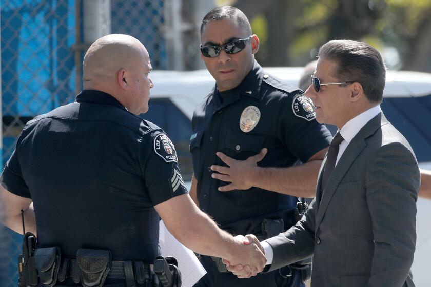 LOS ANGELES, CALIF. - MAR. 9, 2022. LAUSD Superintendent Alberto Carvalho, right, meets with school police officers before entering Crenshaw High School in Los Angeles, scene of a large brawl that involved students and their parents on Wednesday, Mar. 9, 2022. (Luis Sinco / Los Angeles Times)