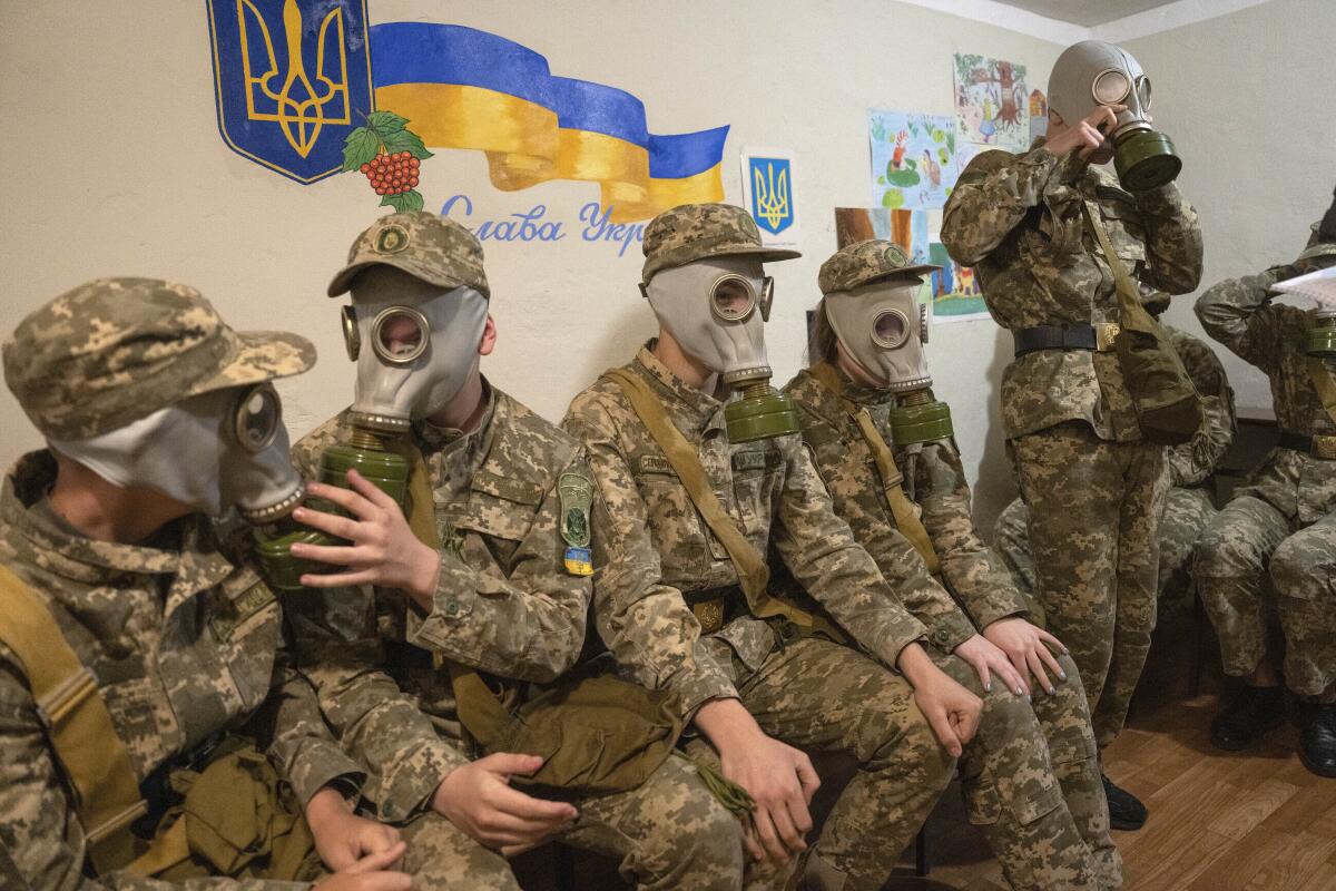 Cadetes practican ponerse máscaras de gas durante una lección en Kiev, Ucrania, el martes 6 de junio de 2023.