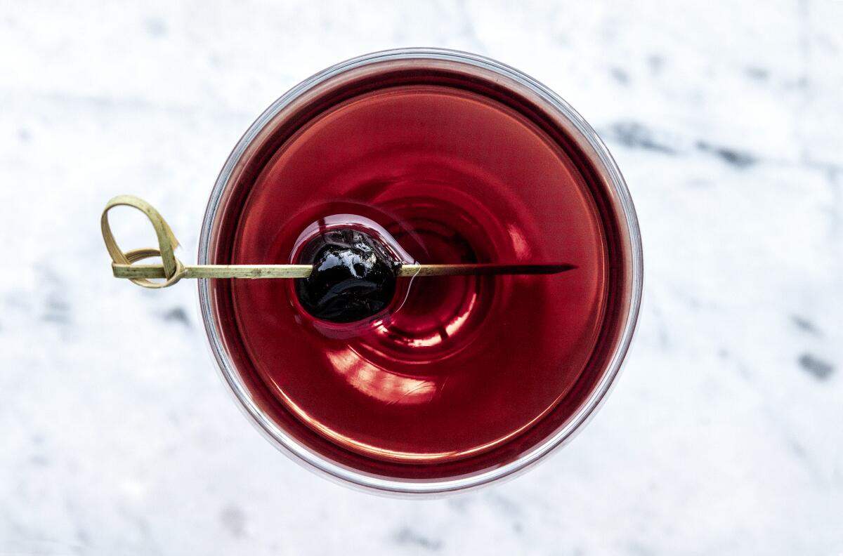 A red cocktail with garnish from Black Market Liquor Bar