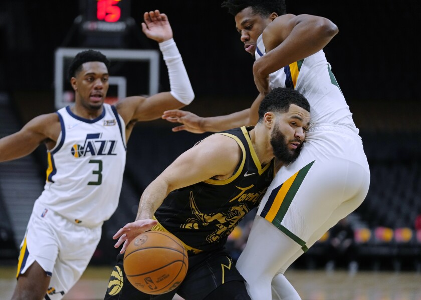 Toronto Raptors guard Fred VanVleet (23) drives against Utah Jazz center Hassan Whiteside (21) as guard Trent Forrest (3) watches during the second half of an NBA basketball game Friday, Jan. 7, 2022, in Toronto. (Frank Gunn/The Canadian Press via AP)
