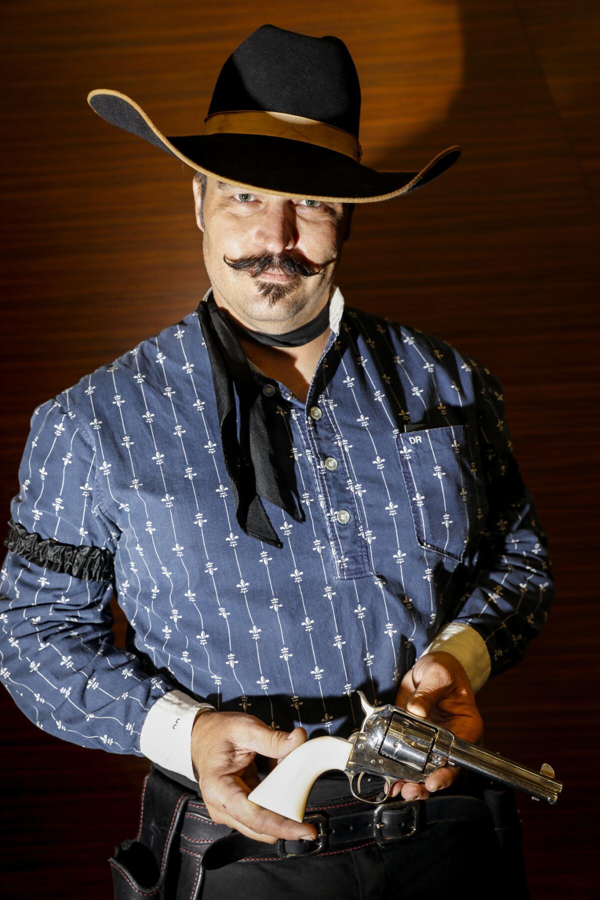 Deke Rivers of Ocala, Fla., an exhibition shooter, performs gun tricks at the booth of Eagle Grips, one of his sponsors that makes custom grips for his pistols, at the NRA meeting in Dallas.