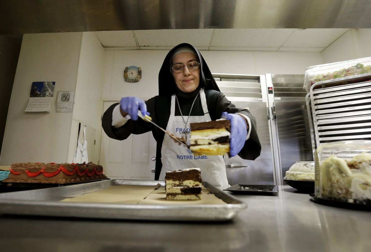 Sister Mary Valerie places cake on a tray to serve at the Fraternite Notre Dame Mary of Nazareth Soup Kitchen in San Francisco.
