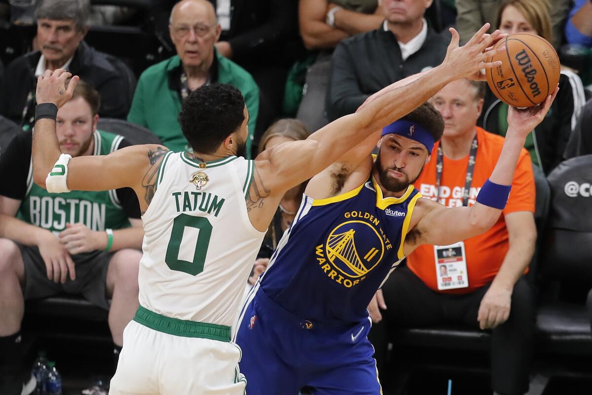 Golden State Warriors guard Klay Thompson looks to pass against the Boston Celtics forward Jayson Tatum.
