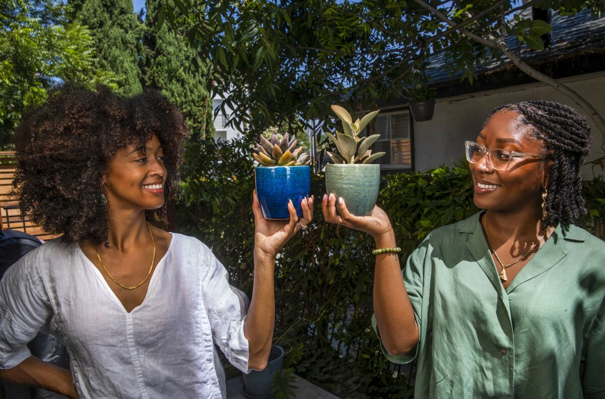 Nicole and Hartfield are photographed in the courtyard of Nicole's home in Silver Lake with some plants that they sell.