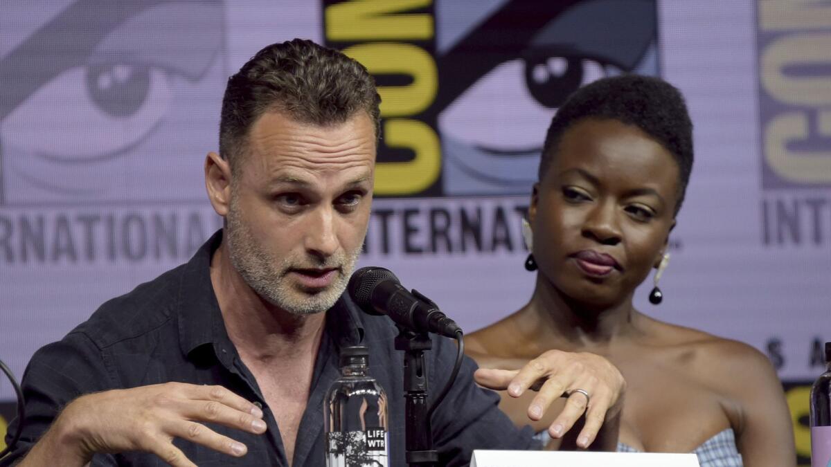 Danai Gurira, right, looks on as Andrew Lincoln speaks at a panel for "The Walking Dead" on day two of Comic-Con International.