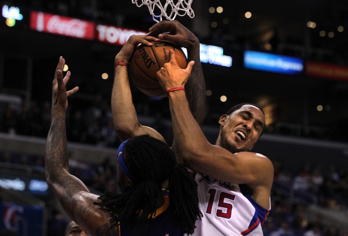 Clippers center Ryan Hollins pulls a rebound away from Lakers power forward Jordan Hill on Friday night.