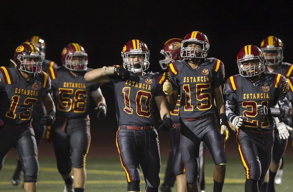 After scoring a touchdown on the opening kickoff, Estancia High's Tyler Ross (10) celebrates with Vincent Durarte (15) and Jordan Alcazar (21) during the Battle for the Bell.