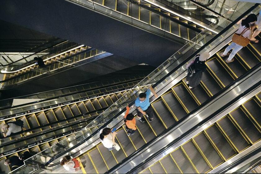 People take elevators at a shopping building in Tokyo on Aug. 24, 2020. Japan’s economy shrank at a record, even worse rate in the April-June quarter than initially estimated. The Cabinet Office said Tuesday, Sept. 8, 2020, Japan’s seasonally adjusted real gross domestic product contracted at an annualized rate of 28.1%, worse than the 27.8% figure given last month. (AP Photo/Eugene Hoshiko)