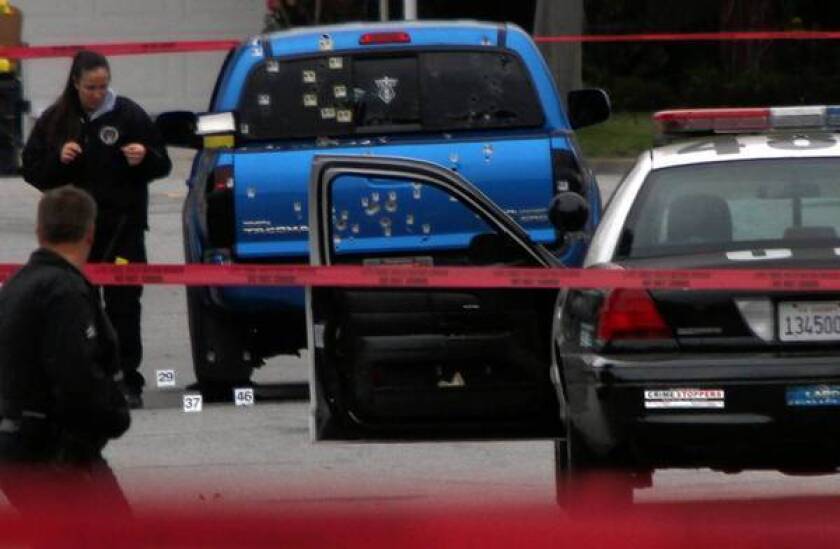 Police investigators examine a blue pickup truck riddled with bullets on Redbeam Avenue in Torrance. Officers, thinking shooting suspect Christopher Dorner might have been in the vehicle, unleashed a fusillade, wounding a woman and her mother.