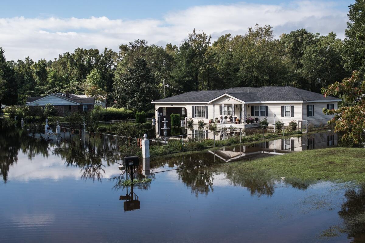 A home in Georgetown, S.C., is inundated by floodwaters from the Black River. Now the state is calling on property owners and homeowner associations to submit repair plans for unsafe dams.