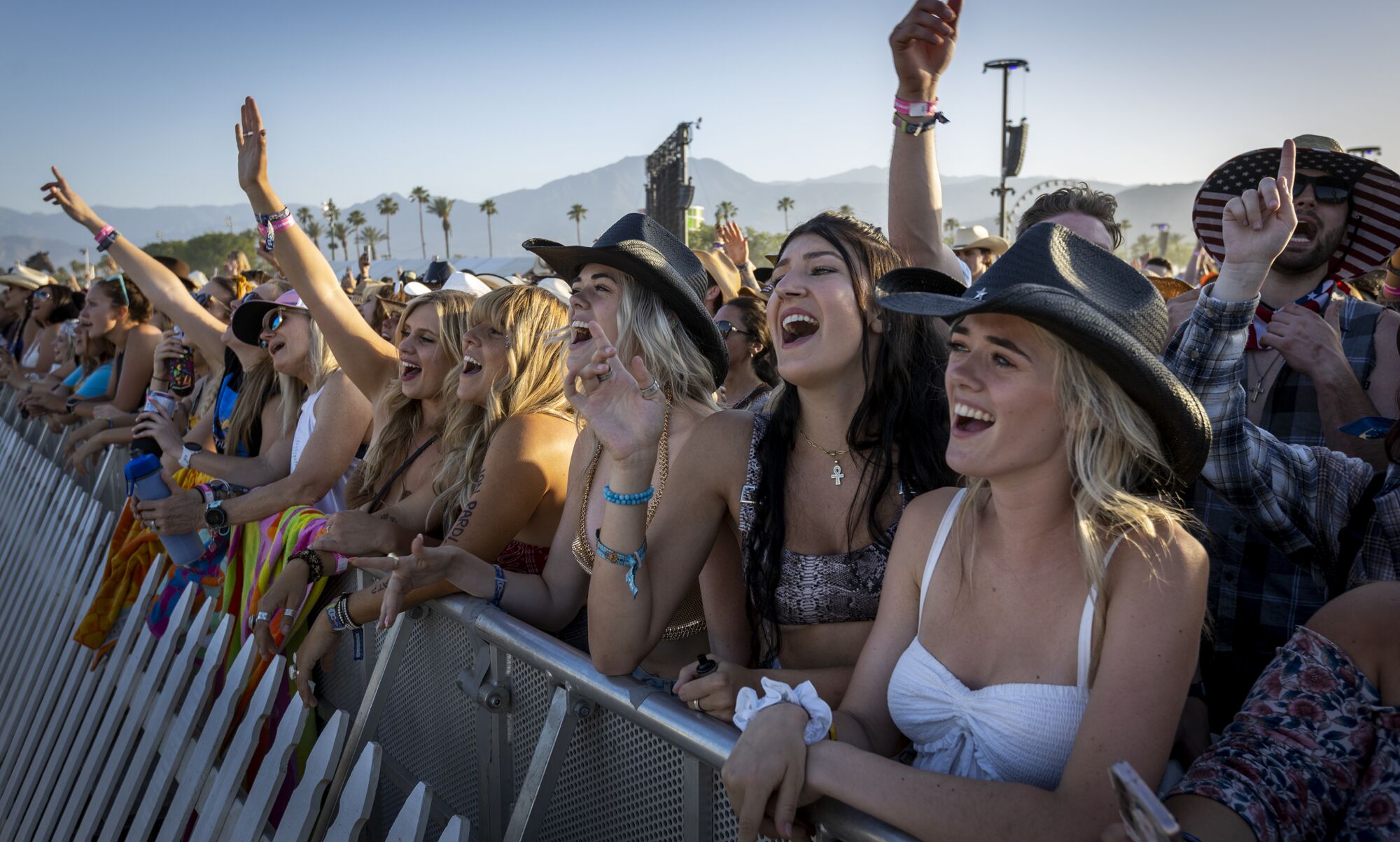 People smile and cheer while watching Midland perform