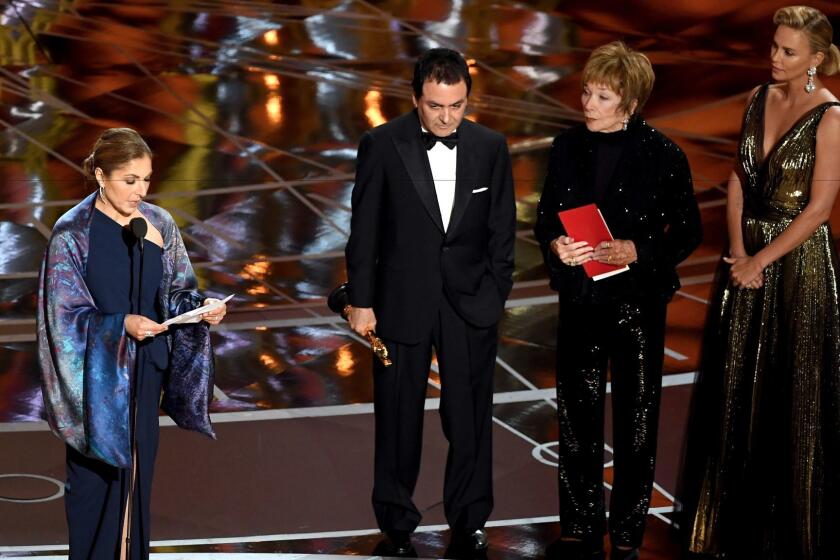 Anousheh Ansari reads a statement on behalf of "The Salesman" director Asghar Farhadi, who won for foreign language film. To her right are former NASA scientist Firouz Naderi with Shirley MacLaine and Charlize Theron.