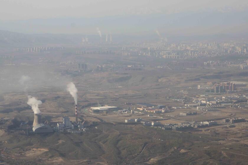 FILE - Smoke and steam rise from towers at the coal-fired Urumqi Thermal Power Plant as seen from a plane in Urumqi in western China's Xinjiang Uyghur Autonomous Region on April 21, 2021. China is promoting coal-fired power as the ruling Communist Party tries to revive a sluggish economy, prompting warnings that Beijing is setting back efforts to cut climate-changing carbon emissions from the biggest global source. (AP Photo/Mark Schiefelbein, File)
