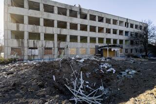 Municipal workers clear the rubble on the roof of College No. 47 which was damaged by a Russian rocket attack in Kramatorsk, Ukraine, Monday, Jan. 9, 2023. (AP Photo/Evgeniy Maloletka)