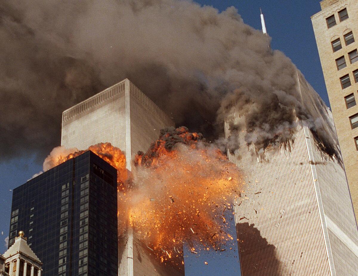 FILE - In this Sept. 11, 2001, file photo, smoke billows from one of the towers of the World Trade Center and flames as debris explodes from the second tower in New York. Relatives of the victims of the Sept. 11 attacks called Thursday, Sept. 2, for the Justice Department's inspector general to investigate the FBI's failure to produce certain pieces of evidence from its investigation. (AP Photo/Chao Soi Cheong, File)