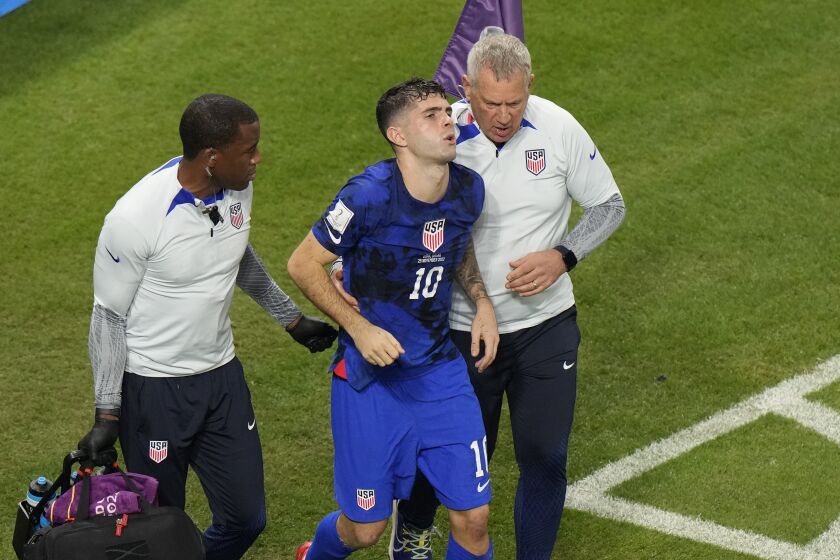 Christian Pulisic of the United States is helped by team doctors after he scoring his side's opening goal during the World Cup group B soccer match between Iran and the United States at the Al Thumama Stadium in Doha, Qatar, Tuesday, Nov. 29, 2022. (AP Photo/Luca Bruno)