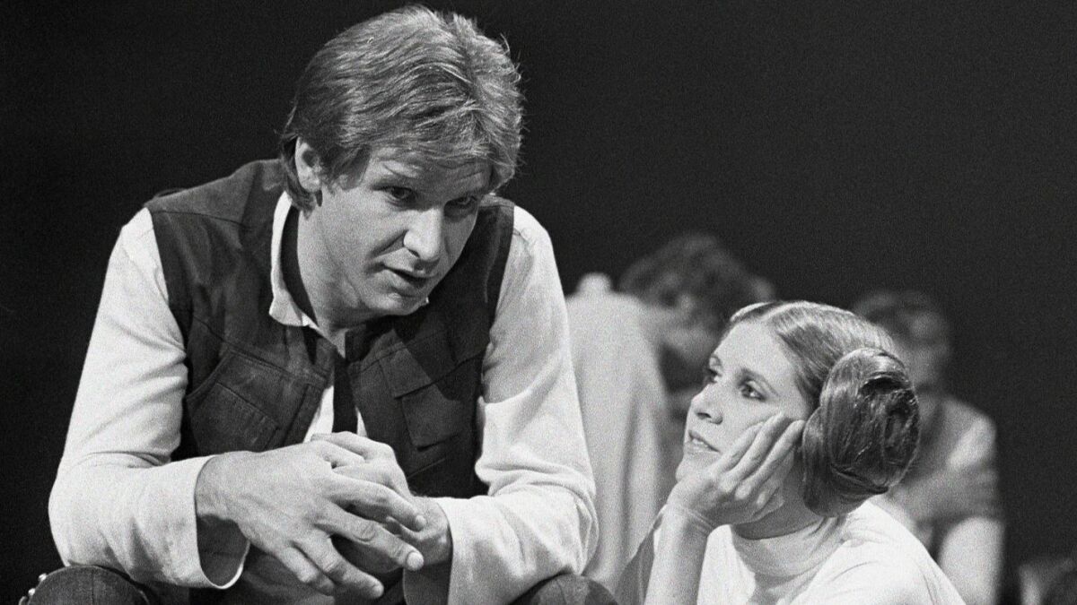 Harrison Ford talks with Carrie Fisher during a break in the filming of "The Star Wars Holiday" in 1978.