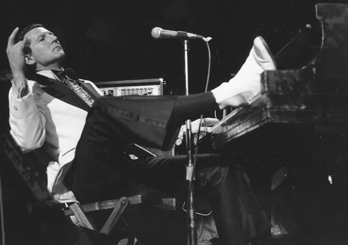 ARCHIVO - Jerry Lee Lewis coloca un pie sobre las teclas del piano 