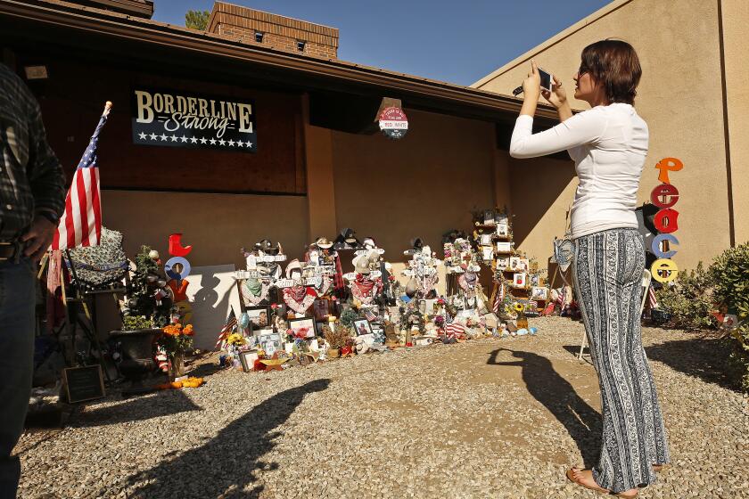THOUSAND OAKS, CA - NOVEMBER 5, 2019 Shaina Miller of Newbury Park who knew 10 of the 12 victims of the Borderline Bar and Grill mass shooting in Thousand Oaks visits the memorial to the 12 victims that continues to stand once a month as people come to pay respects in front of the country-western bar frequented by college students at the one year anniversary of the shooting on Nov 7, 2018. (Al Seib / Los Angeles Times)